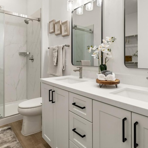 a bathroom with a tub twin sinks and toilet